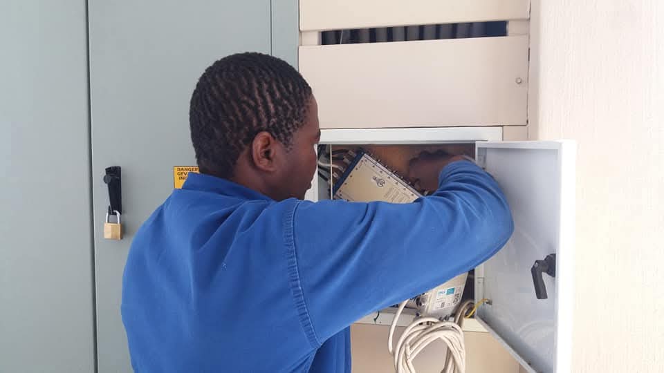 Technician performing maintenance on an electrical control panel