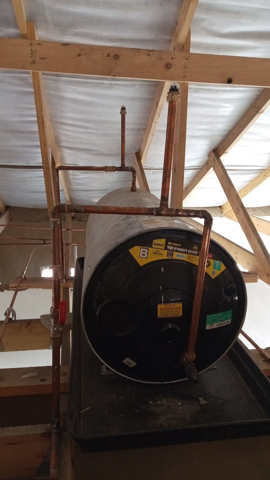 Horizontal high-pressure geyser installed in an attic with copper piping