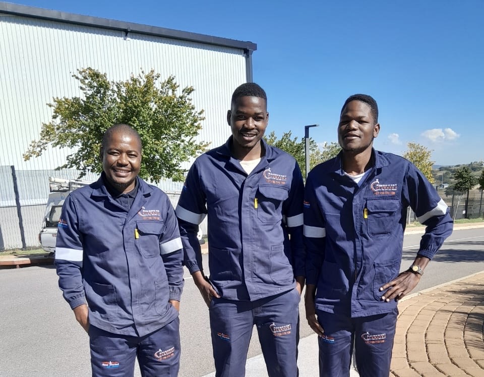 Magnificent Plumbers team in branded blue uniforms outside a job site